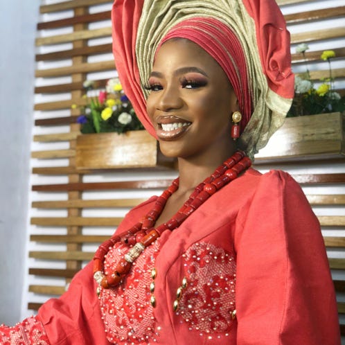 Photo of Man in Red and White Lungi Skirt Standing on Grass Field